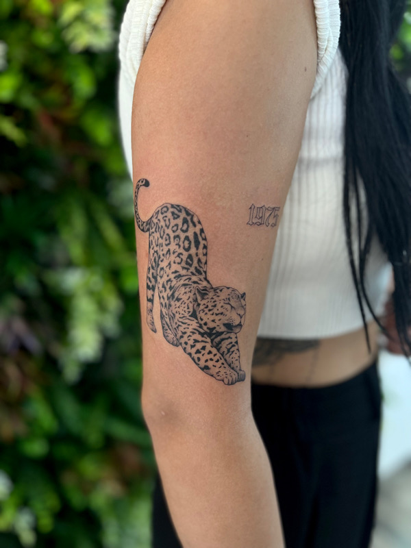 Micro-realistic leopard portrait tattoo located on the
