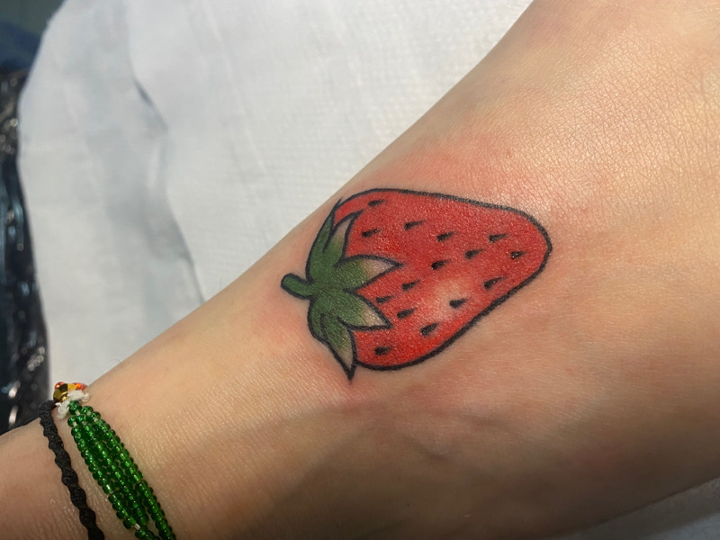 Strawberry tattoo on the ankle.